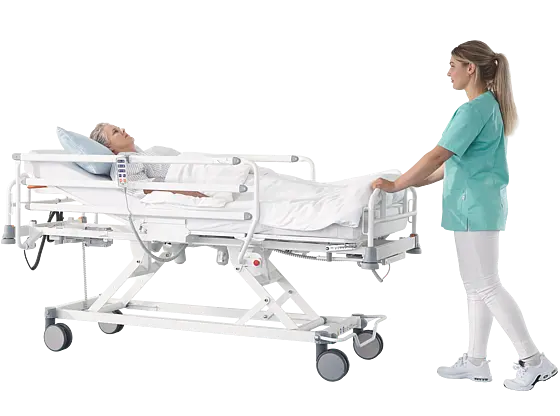 Pflegekraft schiebt Patientin auf Evario one Patientenliege mit Seitensicherungen